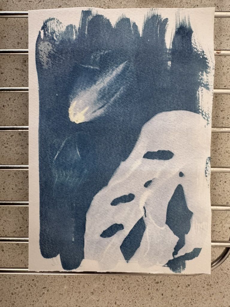 A white paper with blue and white abstract paint on a metal rack.